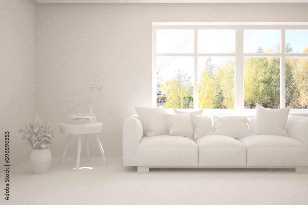 Stylish room in white color with sofa and autumn landscape in window. Scandinavian interior design. 