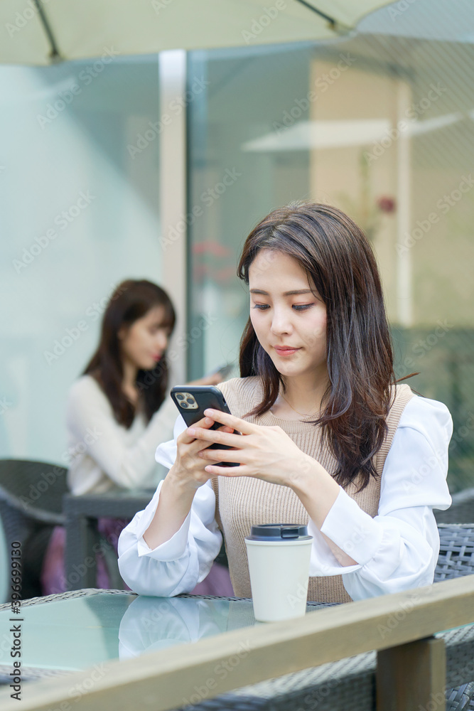 カフェでスマホを使う女性