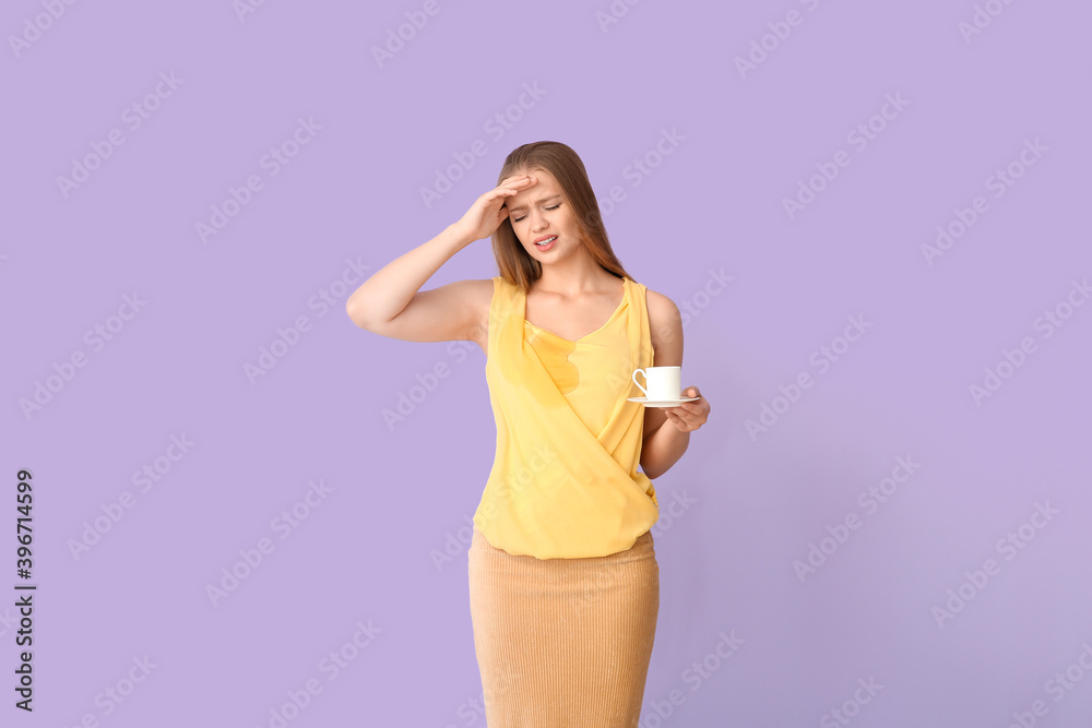 Stressed young woman with coffee stains on her t-shirt on color background