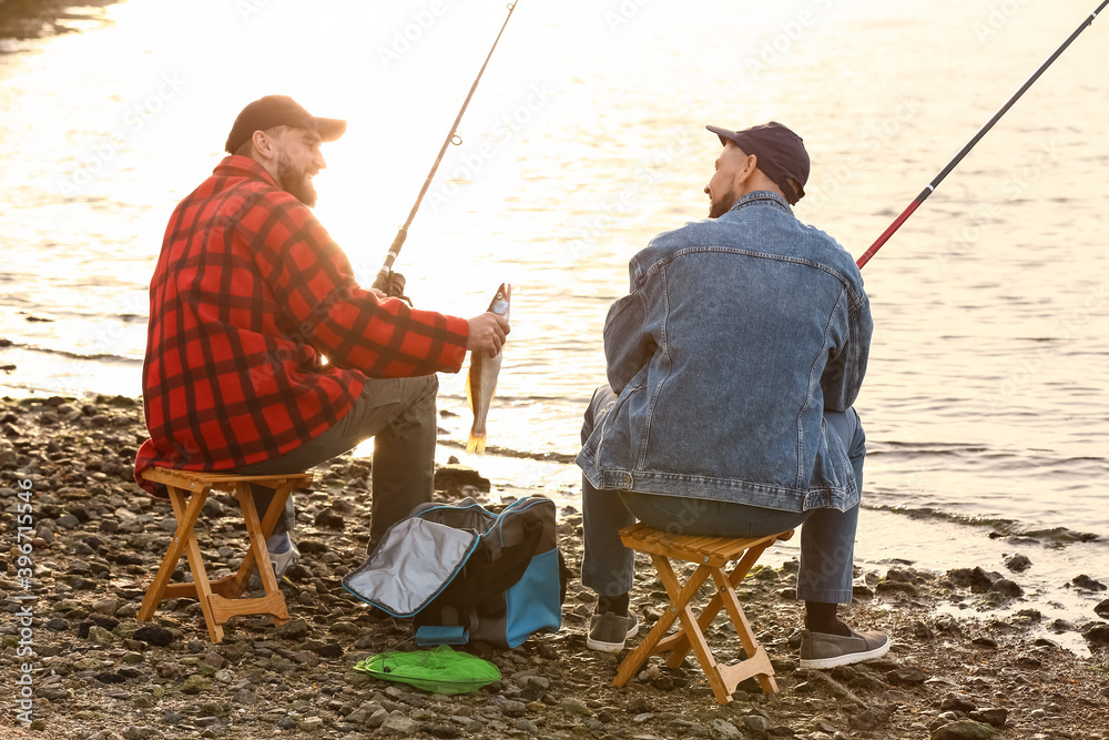 Young men fishing on river