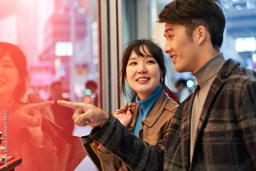 young asian couple shopping in modern city