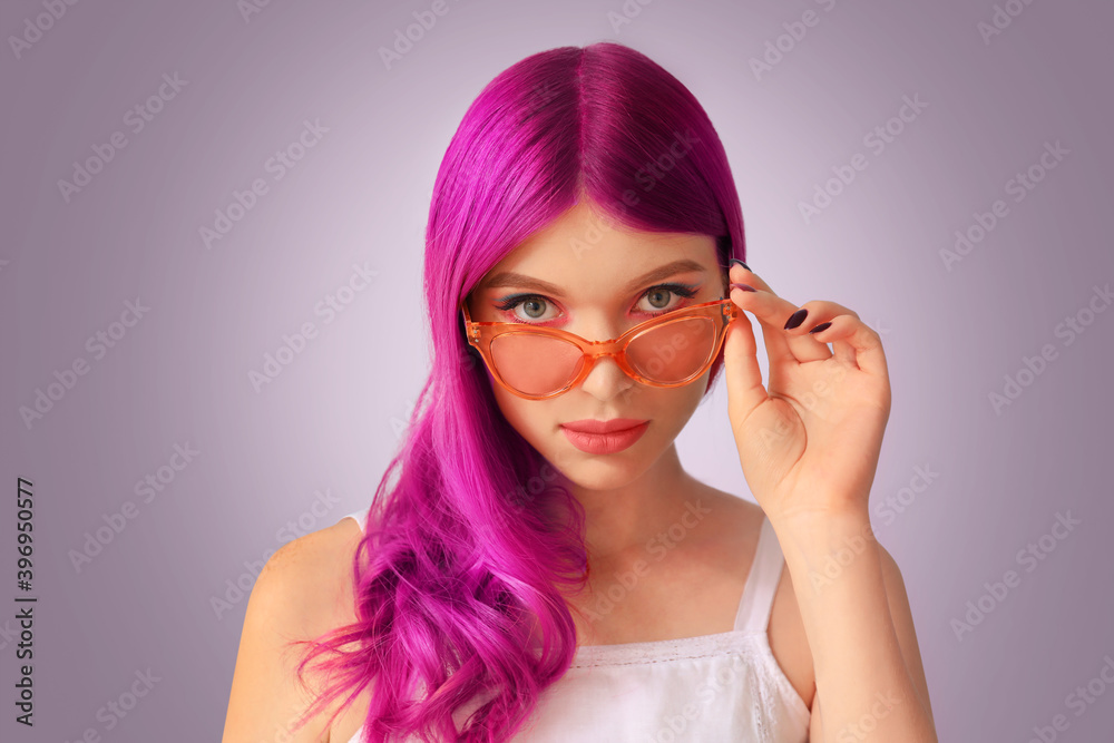 Beautiful young woman with unusual hair on color background