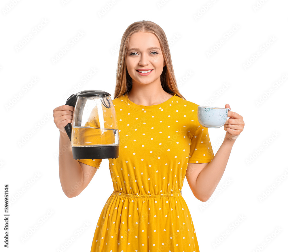 Happy woman holding electric kettle and cup on white background