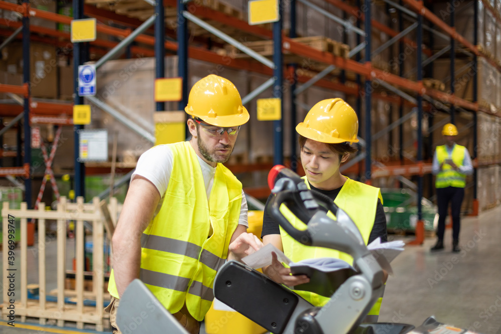 Employees consult while working in the warehouse