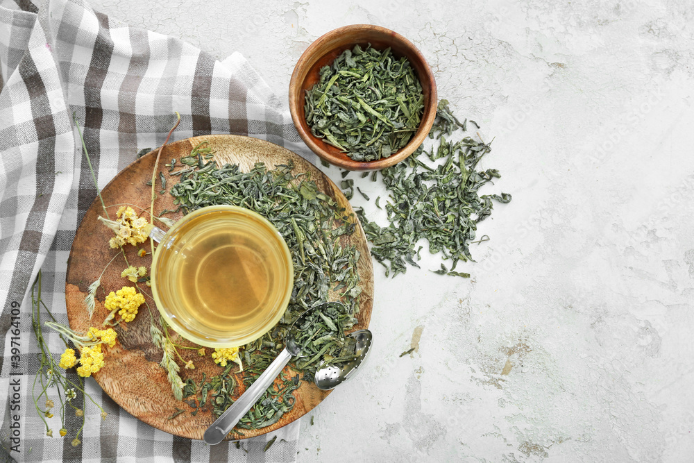 Green tea in cup and dry leaves on table