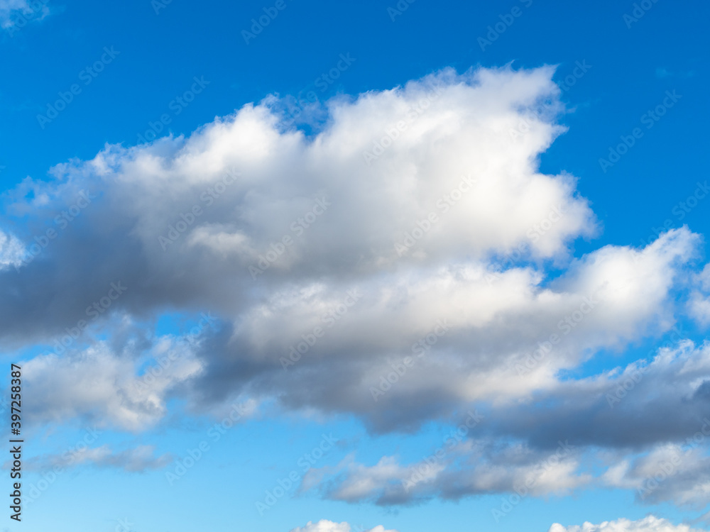 white and gray cumuli clouds in blue sky on sunny November day