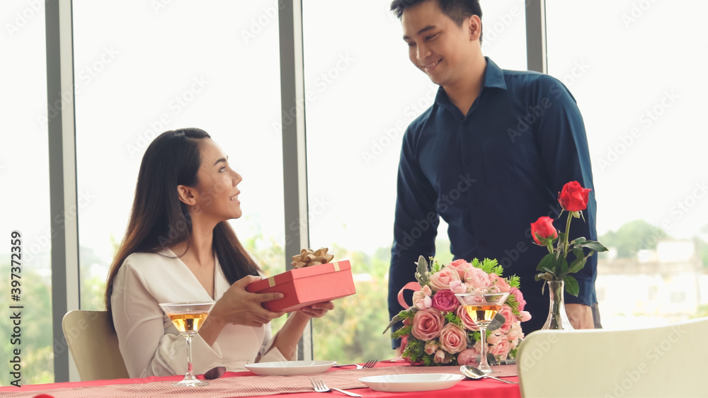 浪漫的情侣在餐厅给爱人送礼物。幸福的情侣生活方式。