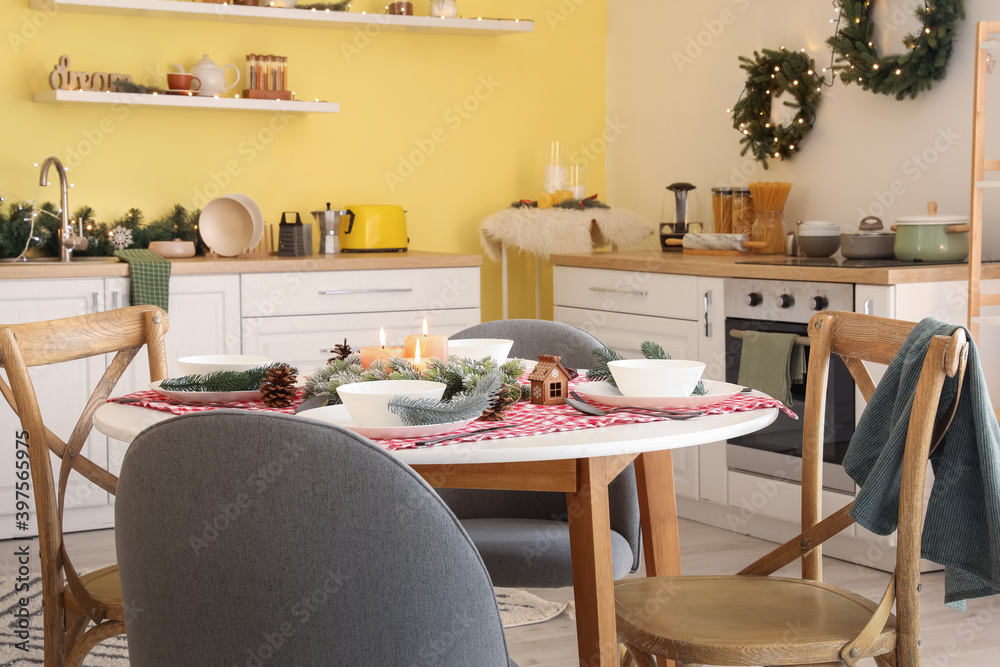 Beautiful table setting for Christmas dinner in kitchen