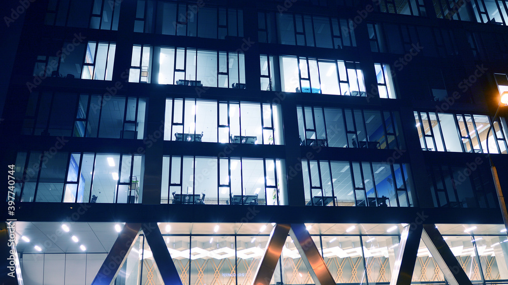 Pattern of office buildings windows illuminated at night. Lighting with Glass architecture facade de