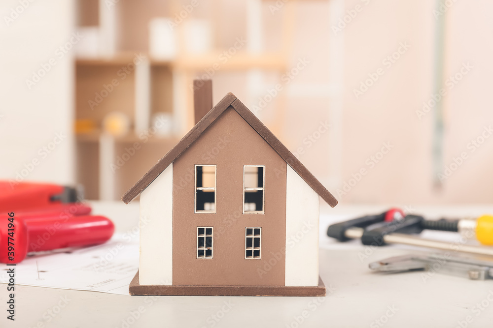 Model of new house with supplies on table