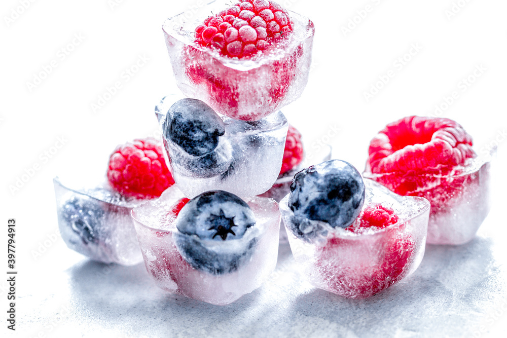 fresh blueberry and raspberry in ice on table background