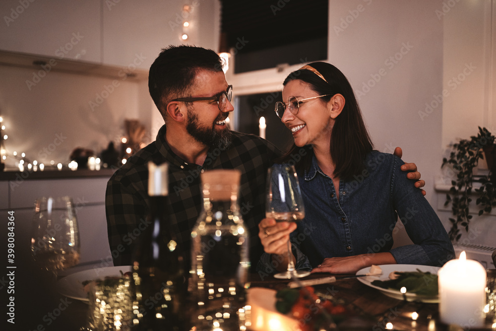 Smiling couple talking together during a candlelit dinner party