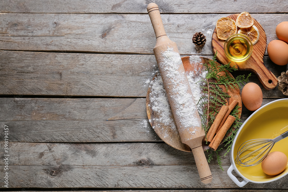 Ingredients for Christmas bakery and kitchen utensils on wooden background