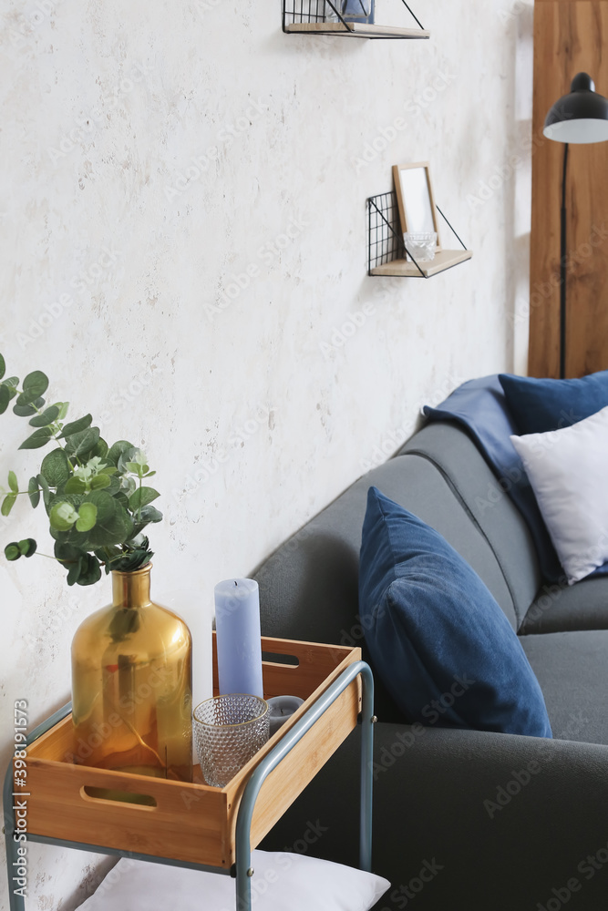 Stylish interior of living room with sofa and table with candles