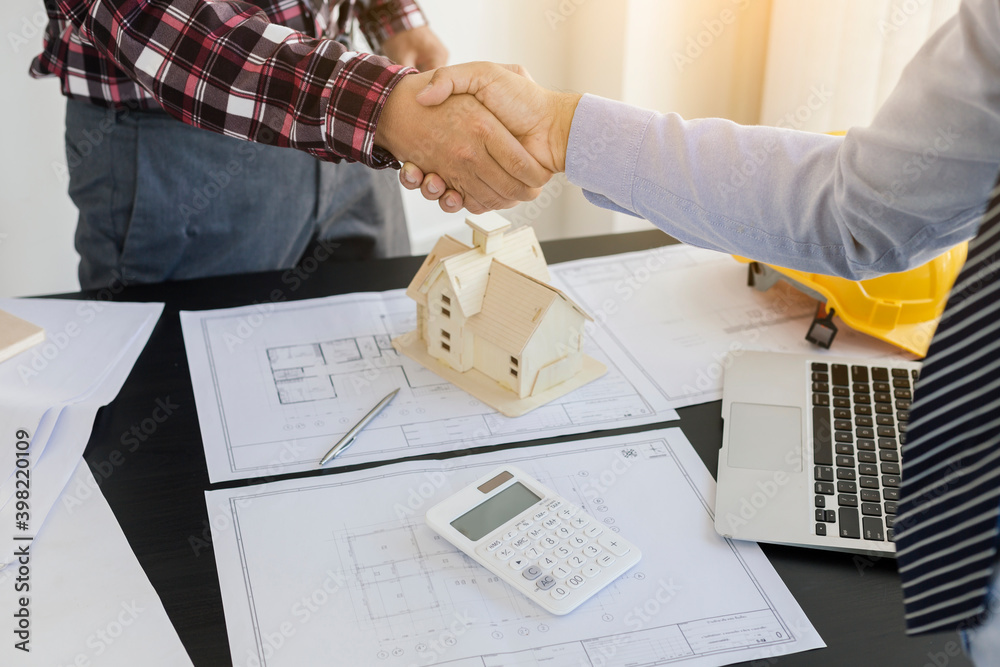 Architect and engineer construction workers shaking hands while working for teamwork and cooperation