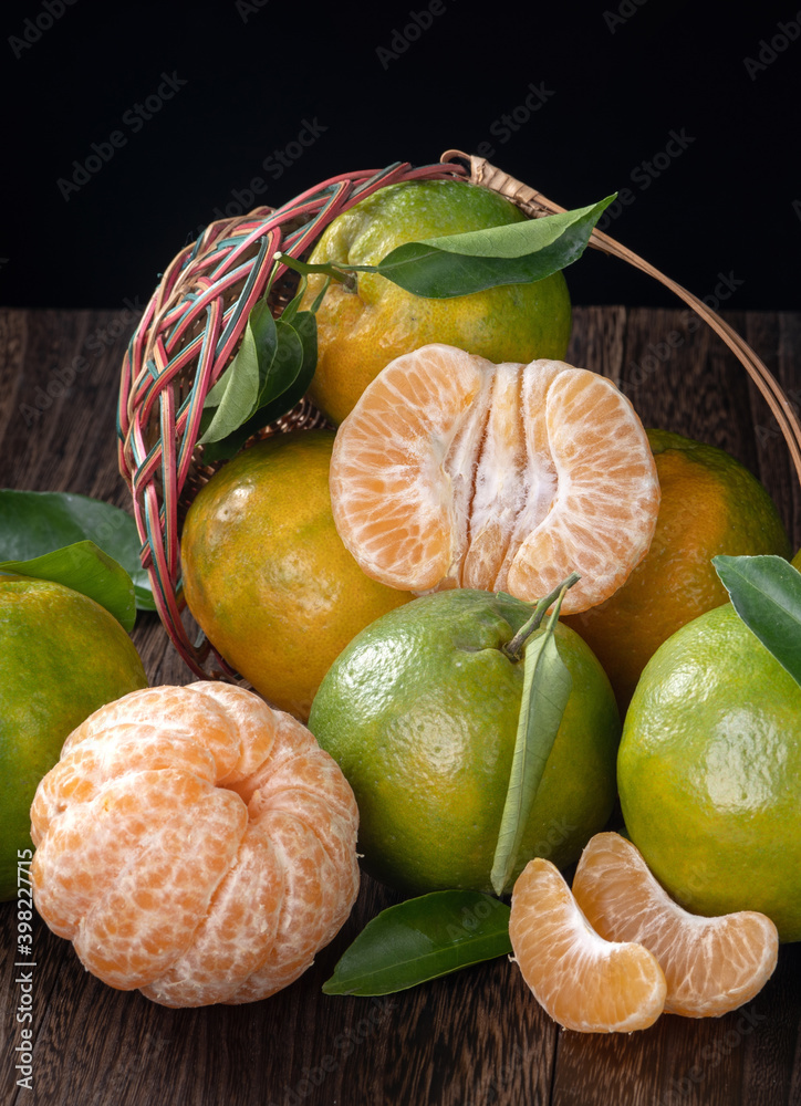 Fresh green tangerine mandarin orange on dark wooden table background.