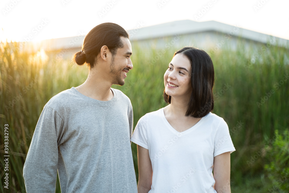 站在草地上的亚洲年轻夫妇的肖像。