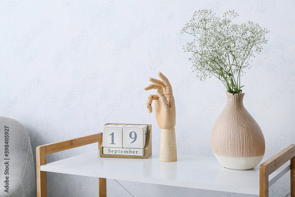 Wooden hand with calendar on shelving