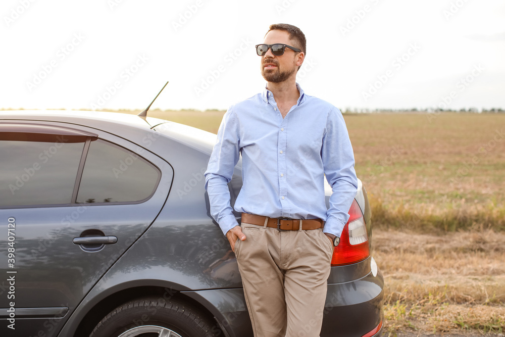 Handsome man near modern car