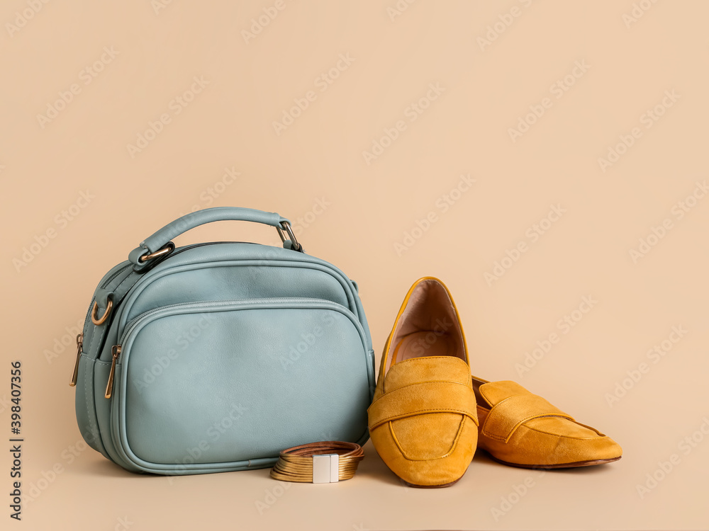 Stylish bag and shoes on color background