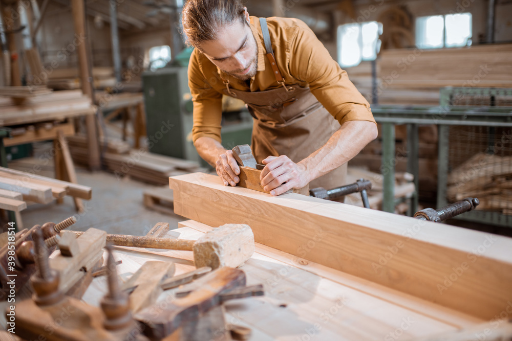 Carpenter working with a wood in the workshop