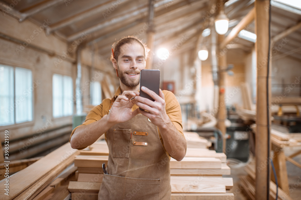 Carpenter using phone in the workshop