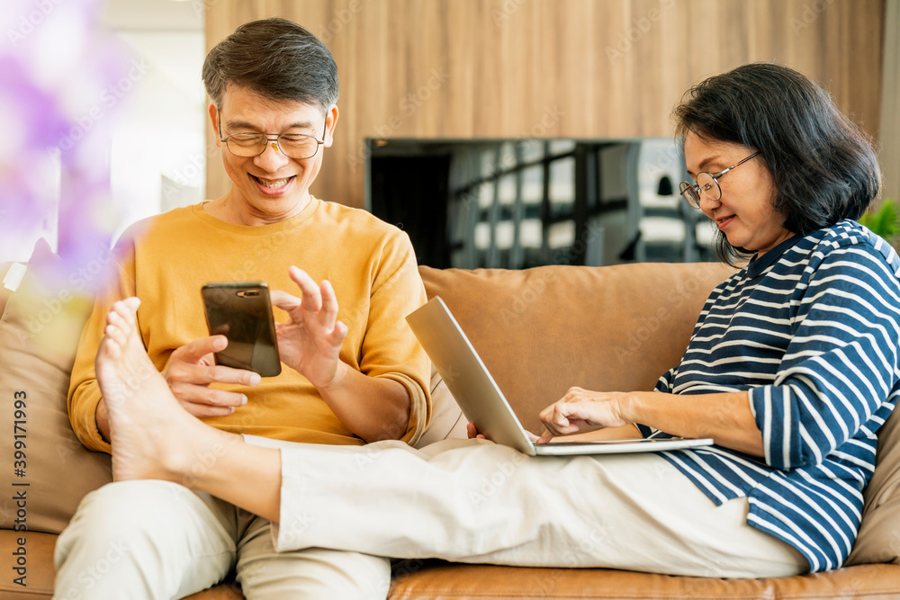 幸福的亚洲老情人夫妇拿着智能手机看着手机屏幕大笑休闲r