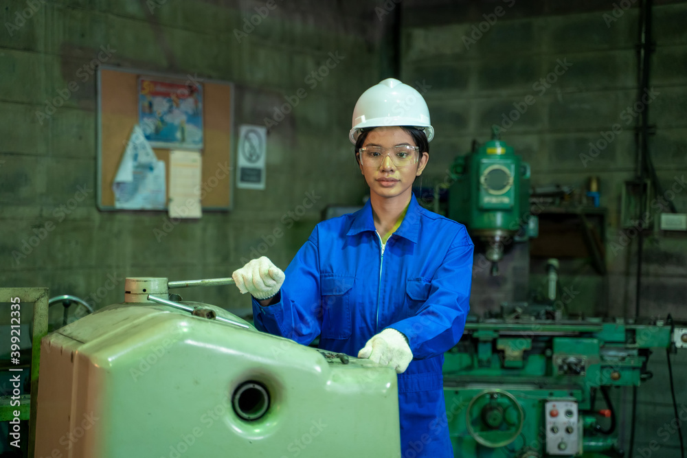 穿着蓝色制服在工厂工作的工程工人女性，工程和工业概念。