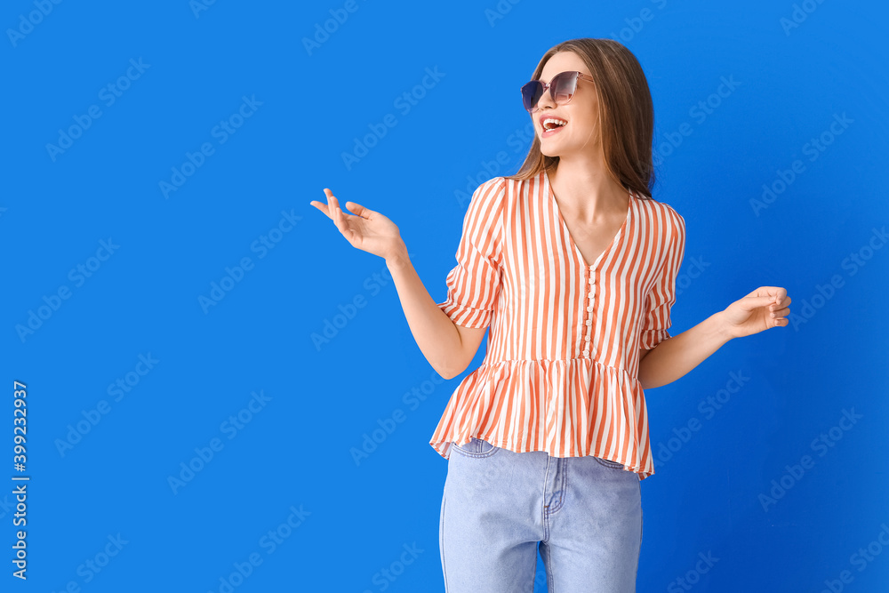 Beautiful woman with stylish sunglasses on color background