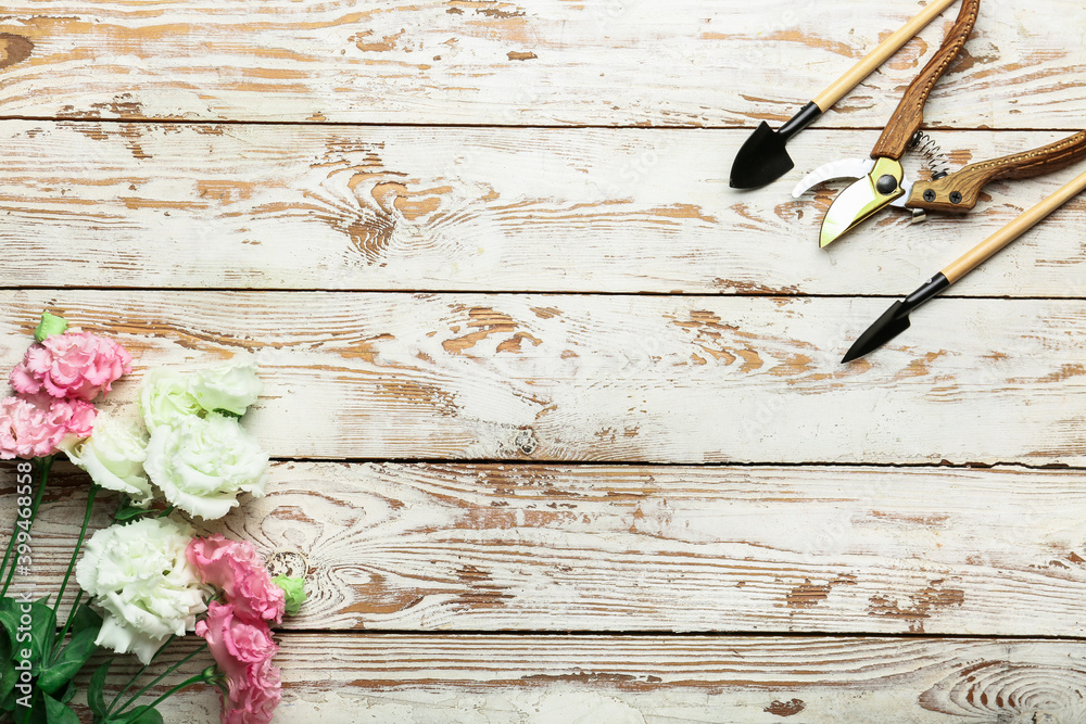 Set of gardening supplies with flowers on wooden background