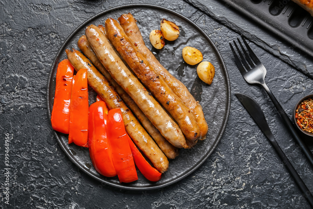 Plate with tasty grilled sausages and vegetables on table