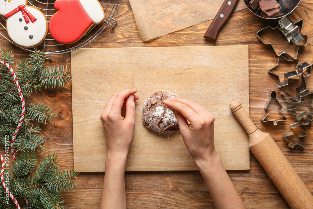 Woman preparing Christmas bakery on table, top view