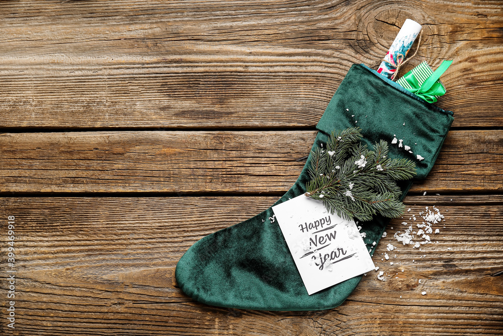 Composition with Christmas sock on wooden background