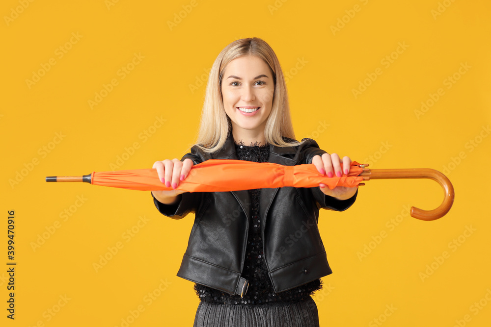 Stylish young woman with umbrella on color background