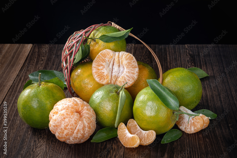 Fresh green tangerine mandarin orange on dark wooden table background.