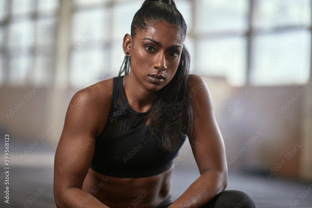 Fit woman sitting in a gym after working out