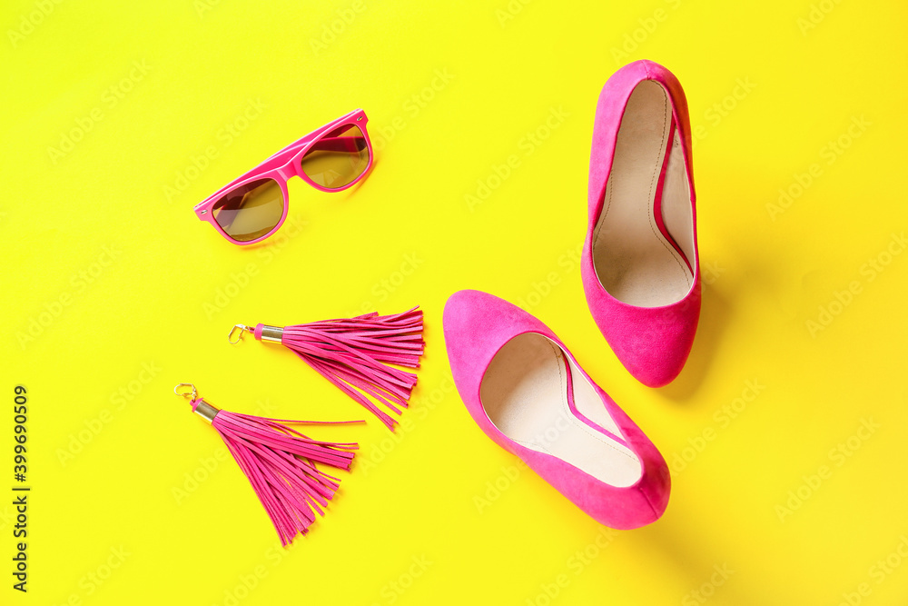 Female shoes and accessories on color background