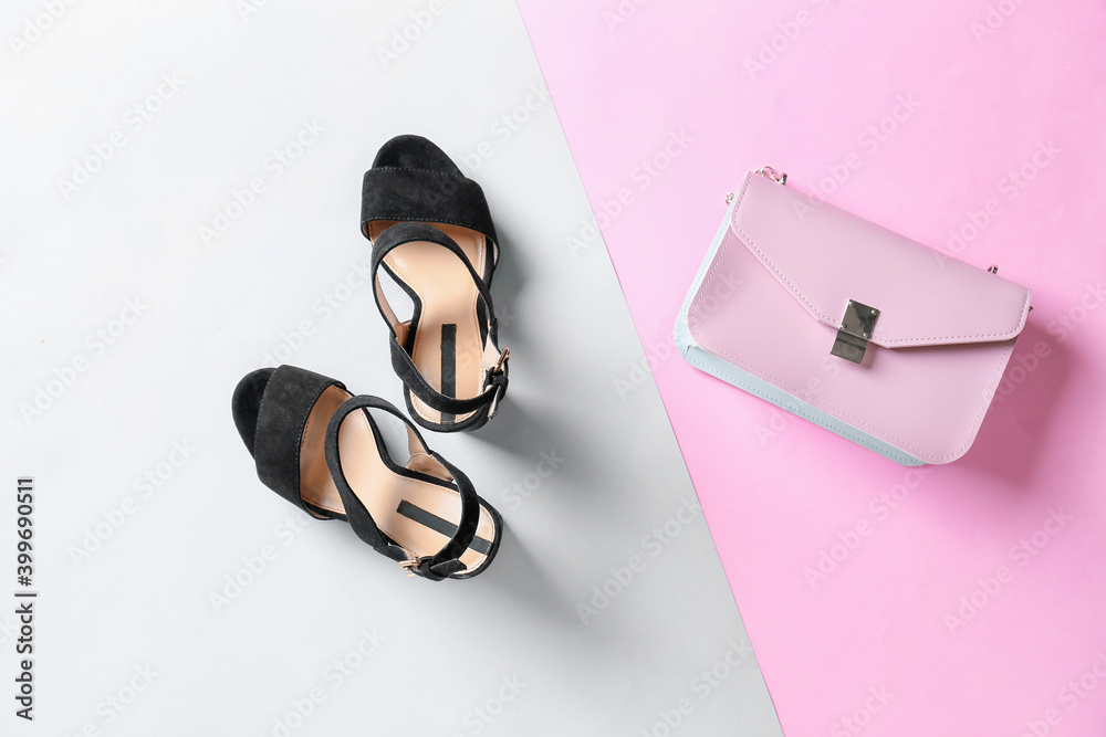 Female shoes and bag on color background