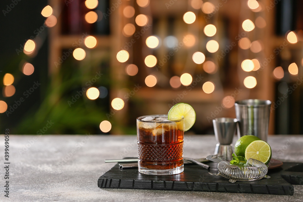 Glass of  Cuba Libre cocktail with lime on table