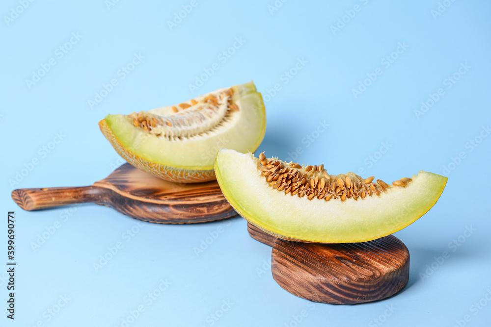 Boards with sweet cut melon on color background