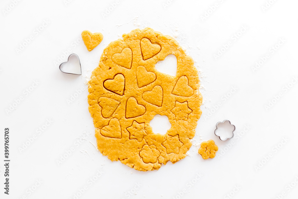 Heart shaped cookies cutting on dough, top view