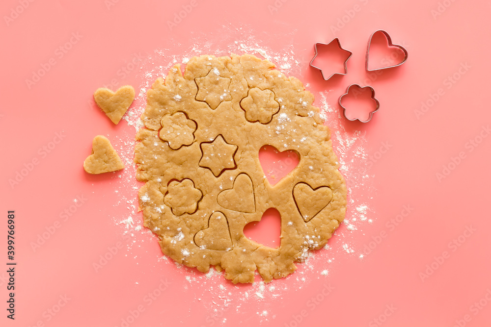 Cutting out heart-shaped cookies on dough top view