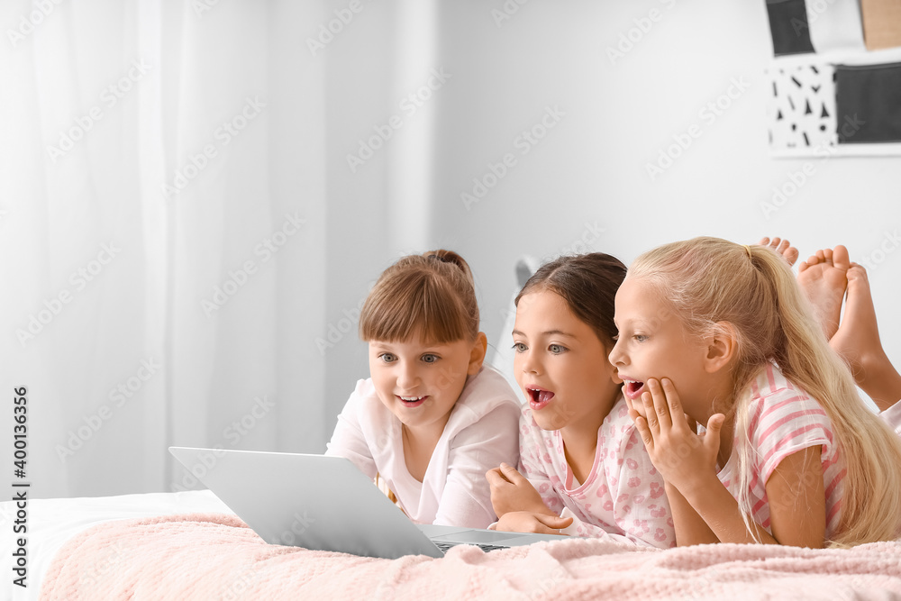 Cute little girls watching cartoons at home