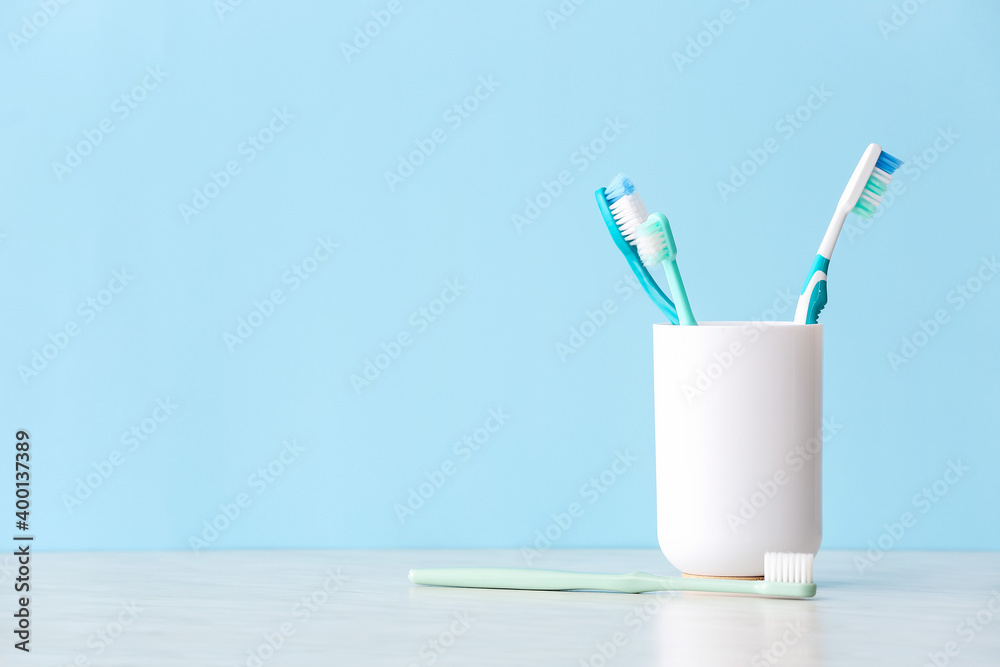 Holder with toothbrushes on table