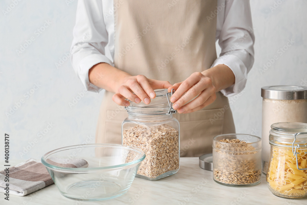 Woman cooking oat flakes in kitchen