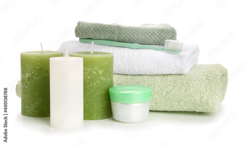 Aroma candles with bathing supplies on white background