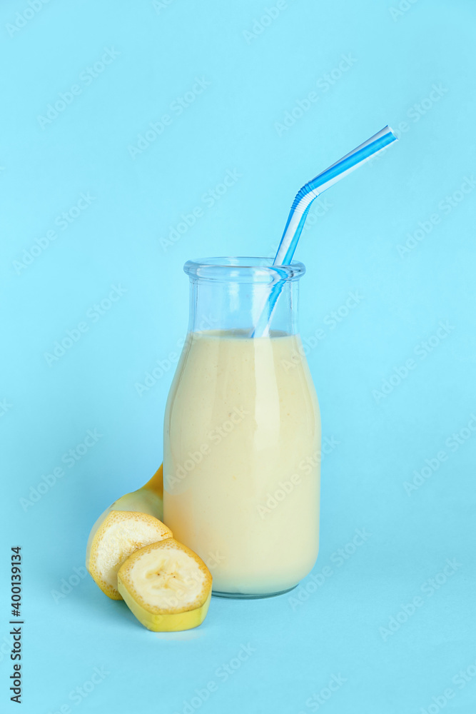 Bottle of tasty banana smoothie on color background