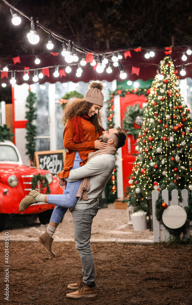 Happy young couple celebrating Christmas outdoors