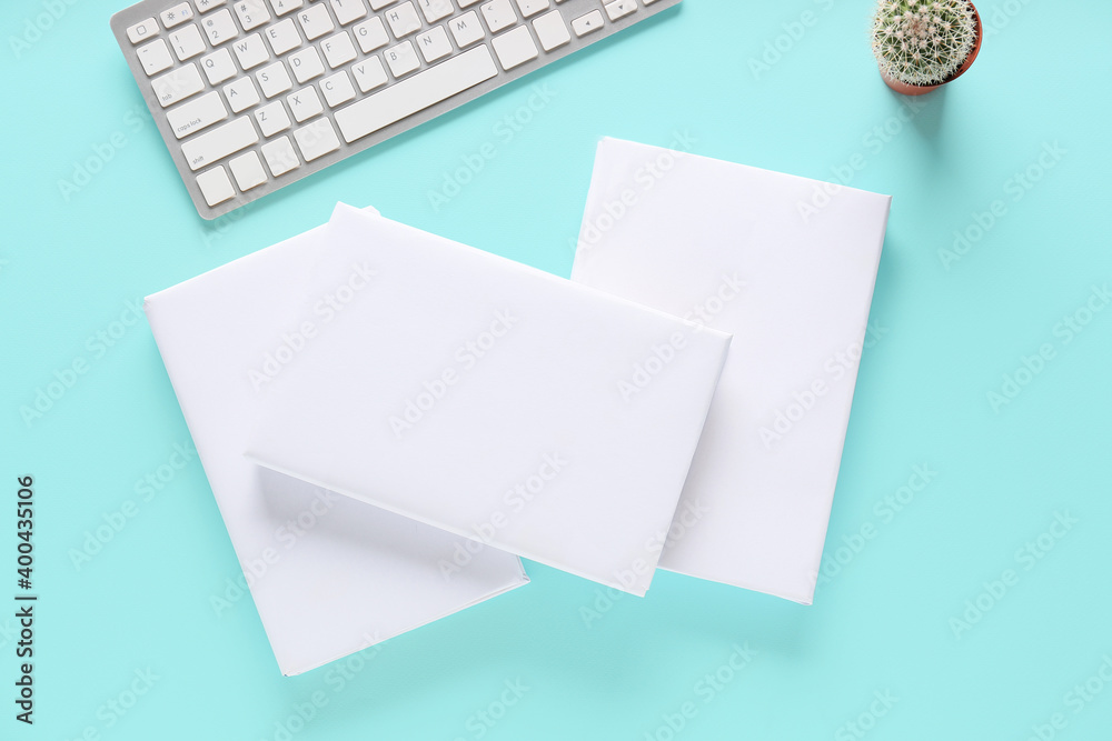 Composition with blank books and computer keyboard on color background