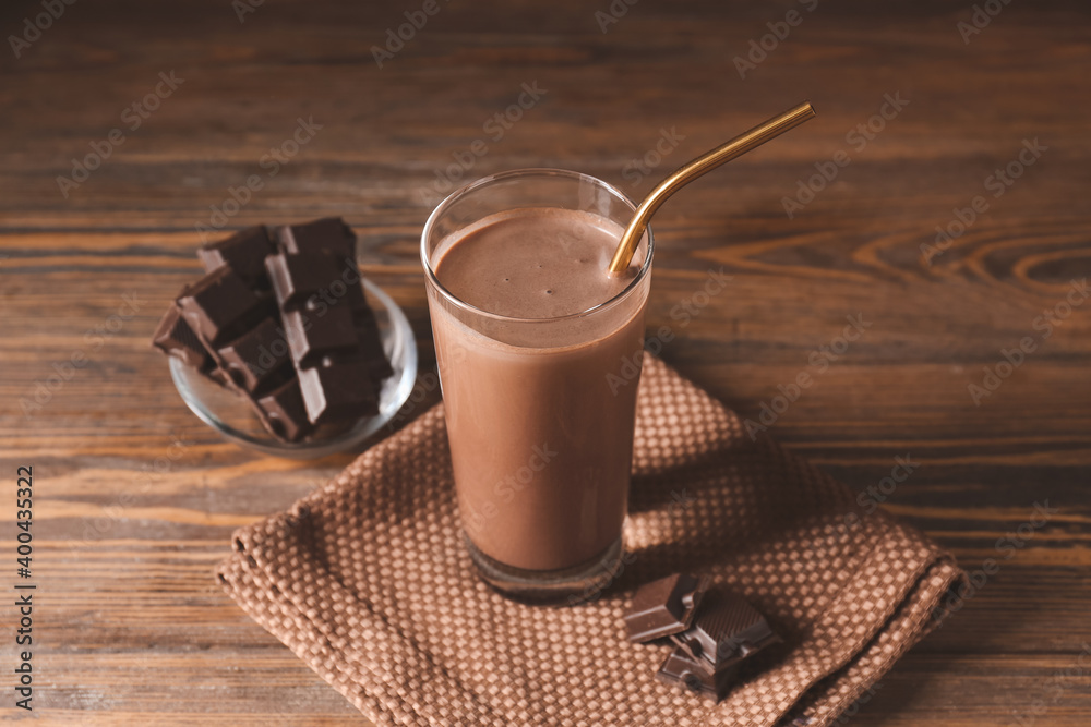 Glass of aromatic chocolate milk on wooden background